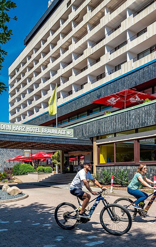 AHORN Harz Hotel Braunlage Aussenansicht im Sommer mit Radfahrern