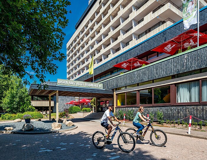 AHORN Harz Hotel Braunlage Aussenansicht im Sommer mit Radfahrern